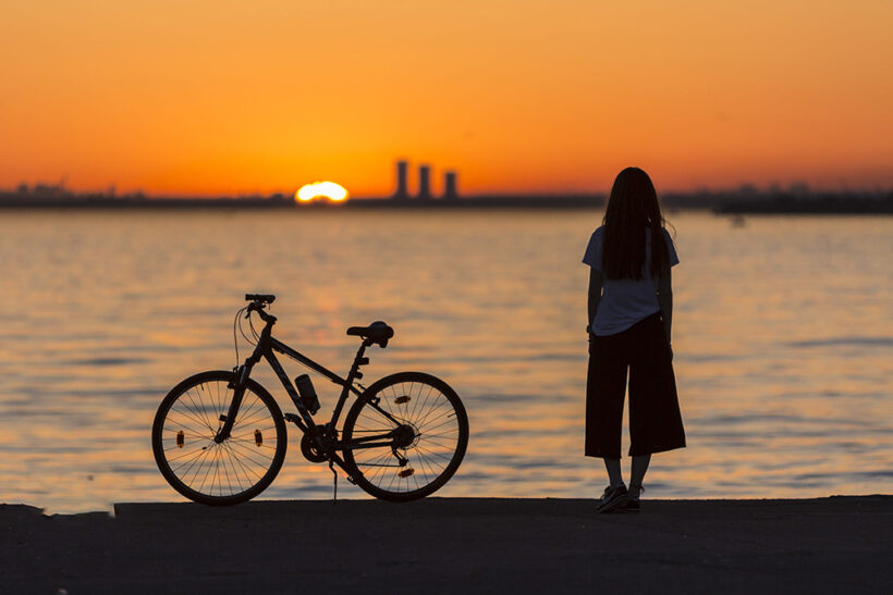 hình ảnh buồn cô đơn thất vọng của cô gái bên bờ biển và chiếc xe đạp
