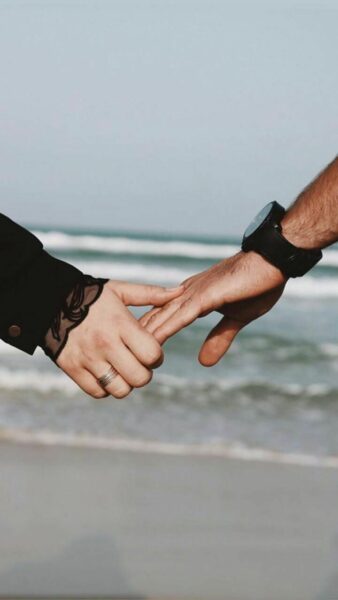 ảnh 2 người nắm tay nhau bên bờ biển ngập nắng