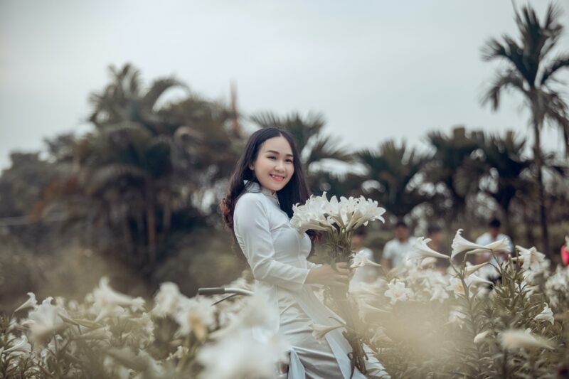 Ảnh cô gái cầm hoa trắng với áo dài trắng