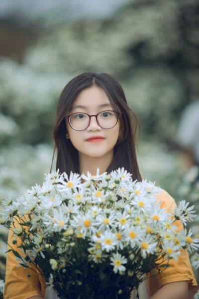 Hình ảnh cô gái cầm hoa cúc lớn