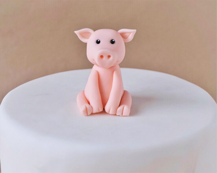 Mẫu bánh sinh nhật con lợn cho người tuổi Hợi nền trắng với một chú lợn ngồi giữa